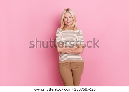 Portrait of pleasant optimistic woman with stylish hairdo wear trendy clothes standing hands crossed isolated on pink color background