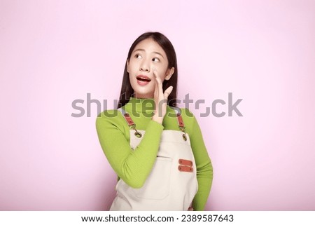 Young woman wearing an apron, Portrait of a beautiful young woman in a light pink background, Shouting with mouth wide open, friendly young woman.