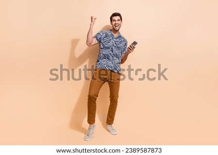Full length size photo of awesome winner holding smartphone shouting hooray girlfriend answer sms isolated on beige color background