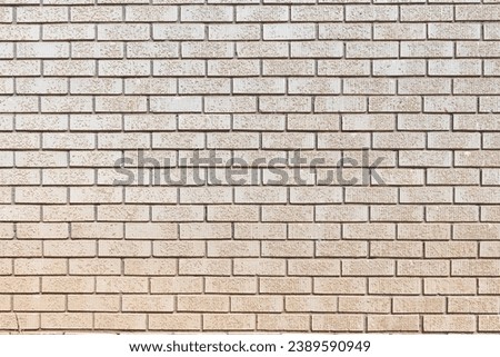 Detail of a yellow cream colored brick wall with medium grey grouting, abstract background texture of an old brick wall.