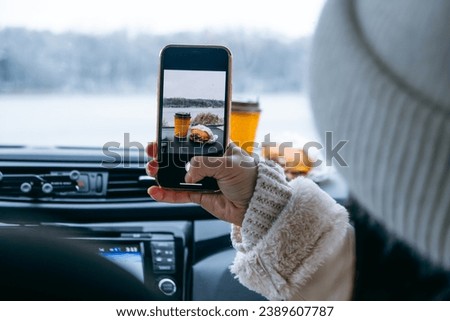 woman take picture of burger at car dashboard