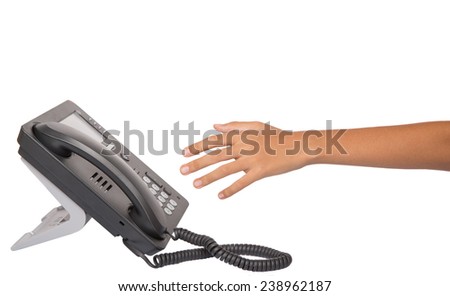 Female hand reaching for desktop telephone handset over white background 