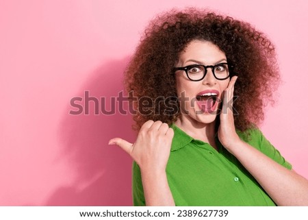 Photo portrait of attractive young woman point fingers empty space excited wear trendy green clothes isolated on pink color background