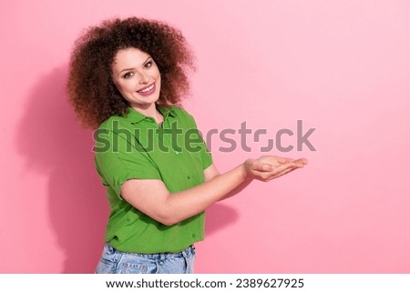 Photo portrait of attractive young woman palms hold empty space promotion wear trendy green clothes isolated on pink color background