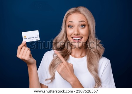 Photo of excited surprised girl wear white trendy clothes hold bank plastic card isolated on dark blue color background