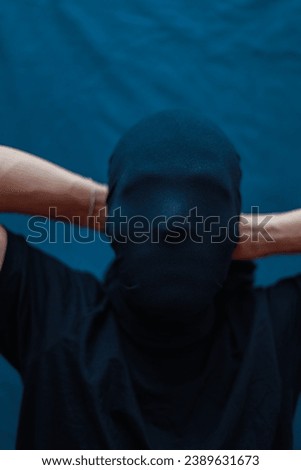 Anonymous, horror criminal, mental, hacker, psycho, boy laughing, shouting, covering face using cloth. COVID-19 Coronavirus depression, anxiety, trauma issue photoshoot in black studio lighting