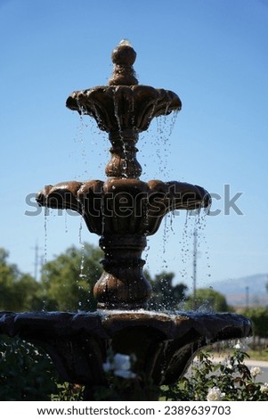 A water fountain in the garden with a blue sky background