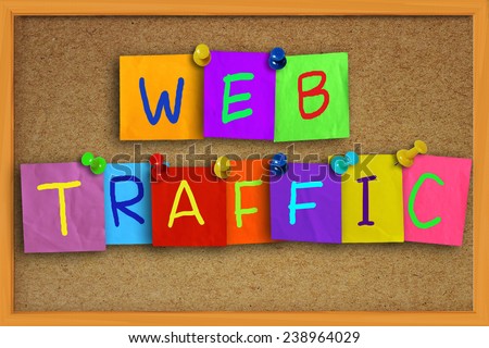 Internet concept image of the word Web Traffic written on sticky colored paper over cork board
