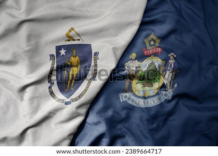 big waving colorful national flag of maine state and flag of massachusetts state . macro