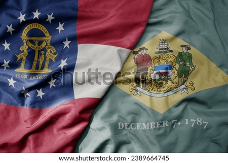 big waving colorful national flag of delaware state and flag of georgia state . macro