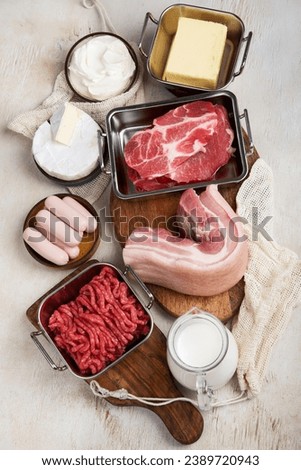 Saturated fats on tables. Raw meat, sausages, cheese, butter. Bad food concept. Top view. Royalty-Free Stock Photo #2389720943