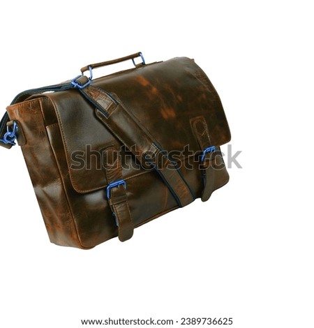 Brown leather briefcase bag, postman style. Handmade brown bag with strap to hang on the shoulder or hold the object with the hand. Type suitcase, haversack or satchel, isolated on white background Royalty-Free Stock Photo #2389736625