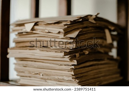 A vintage pile of old brown leather books on a wood table.
