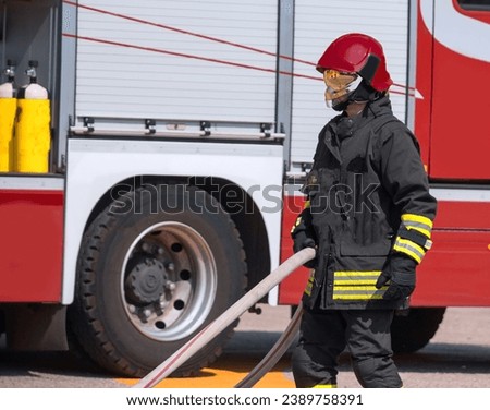 firefighter with red helmet and fire truck on background