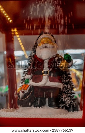 large christmas decoration with santa claus and falling snow