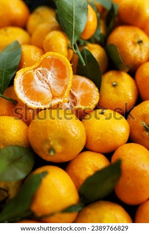 Fresh, juicy tangerine slices or tangerines with leaves as a background Royalty-Free Stock Photo #2389766829