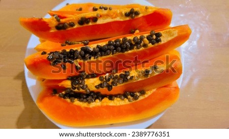 Papaya fruit that has been peeled, arranged on a plate, still has the seeds