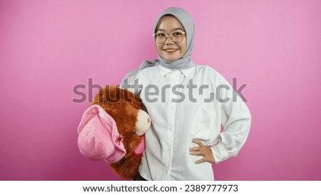 Muslim woman is carrying a teddy bear