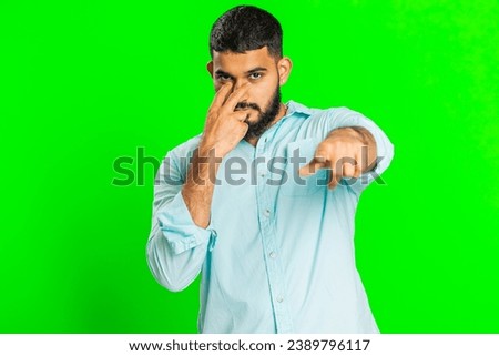 I am watching you. Confident attentive man pointing at her eyes and camera, show I am watching you gesture spying on someone. Handsome disappointed Indian guy isolated on green chroma key background