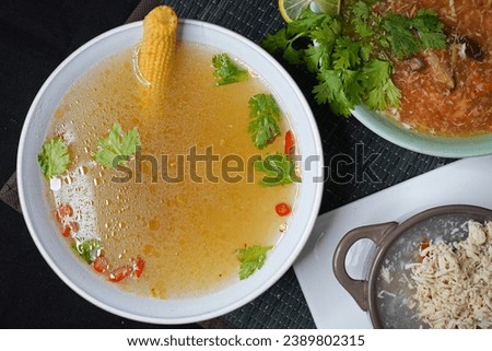 Clear Thai soup close up shot, top view and along with hot  sour and chicken corn soup with French bread. three different pictures. white bowl and grey background