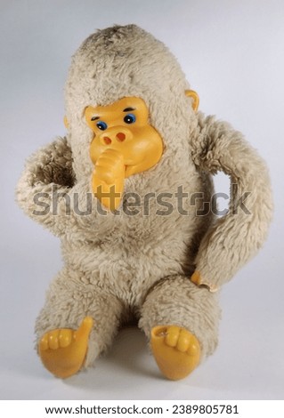 Baby monkey,  toy.  Sitting while sucking the thumb