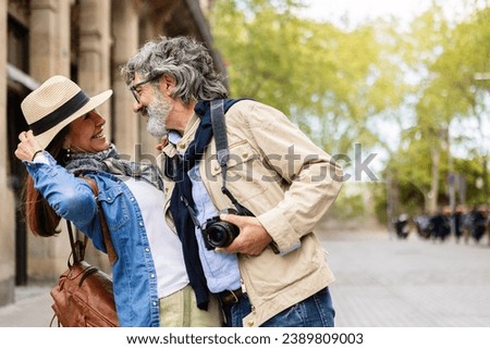 Lovely senior couple of tourist enjoying vacation together in city street. Older mature people in love having fun sightseeing european city during vacation or weekend getaway. Copy space for text Royalty-Free Stock Photo #2389809003