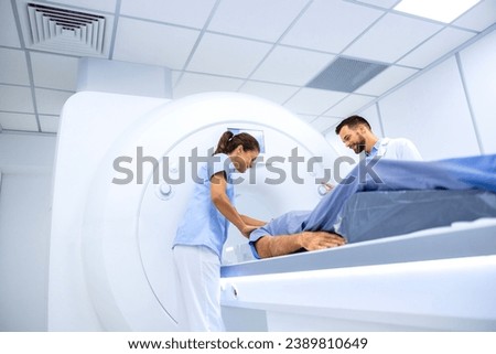 Doctors preparing patient for full body scanning procedure inside MRI diagnostic center. Royalty-Free Stock Photo #2389810649