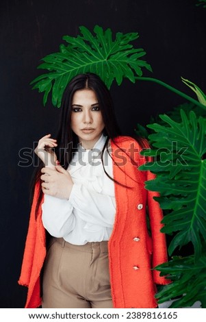 business woman brunette at a decorative flower on a black background