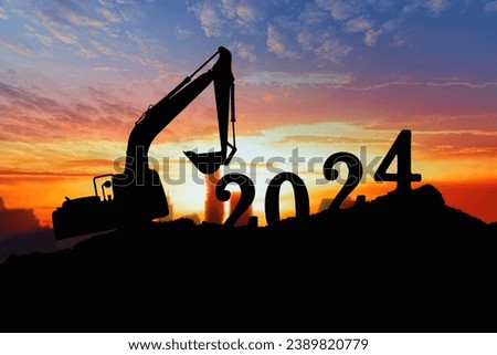Concept happy new year 2024,crawler excavator silhouette with lift up bucket .On sunrise backgrounds