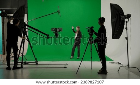 News anchor at work, woman journalist presenter telling weather news, view of a backstage studio TV news shooting, chroma key template.