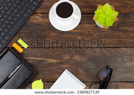 Wooden office table with computer, pen and a cup of coffee, lot of things. Top view with copy space