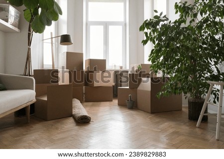 Empty living room with stacked cardboard boxes with personal belongings on relocation day, prepare house for repair or remodeling work, no people. Bank mortgage, new affordable dwelling and renovation Royalty-Free Stock Photo #2389829883