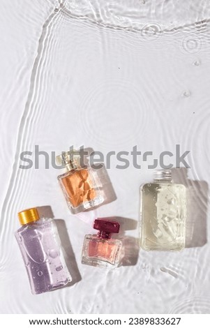 Vertical image of beauty product bottles in water with copy space background on white background. Health and beauty, make up and beauty concept.