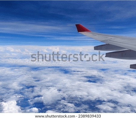 Airplane above the clouds and a clear sky. Royalty-Free Stock Photo #2389839433
