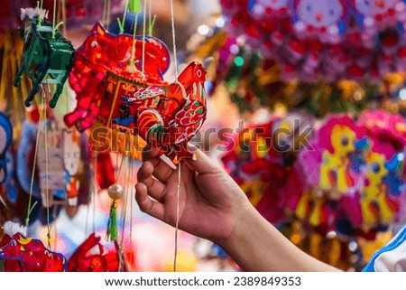 Colorful decorated lanterns hang on the streets in Ho Chi Minh City, Vietnam during the Mid-Autumn Festival. The Chinese in the picture means money and happiness. Selective focus.