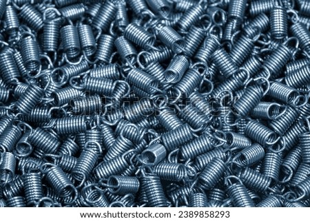 The group of metal coil spring parts in the light blue scene. The coil spring manufacturing concept. Royalty-Free Stock Photo #2389858293