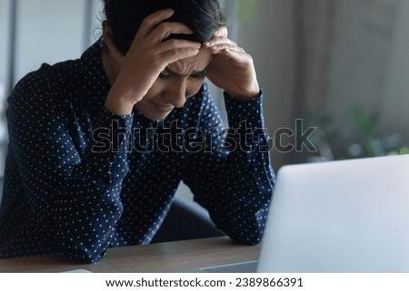Frustrated upset office employee, student shocked with bad surprise, getting concerning news, sitting at laptop, feeling depresses, anxious, regret, despair. Depressed Indian woman crying at computer Royalty-Free Stock Photo #2389866391