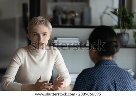 Serious vacancy candidate, speaking to employer, hr agent, recruiter at job interview. Confident mentor training intern, explaining project task. Colleagues, business partners meeting and talking Royalty-Free Stock Photo #2389866395