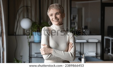 Happy thoughtful business woman, entrepreneur in casual standing with folded arms, looking at window in good thoughts and smiling, dreaming of successful future career, Head shot portrait