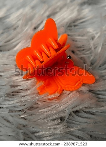 Children's hair clips that are cute and red in color. and has a butterfly texture