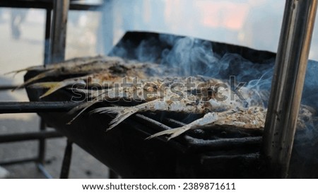 Grilling fish in open air restaurant. Selective focus.