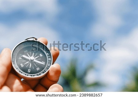 hand holding compass, blue sky copy space background, travel and lifestyle, planning and manage to success business concept