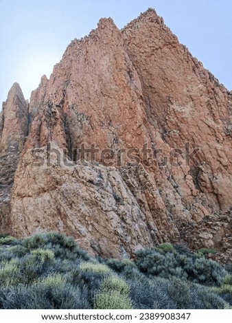 Surroundings of Teide. Volcano located on the Spanish island of Tenerife, you can see the inhospitable terrain, blue sky, large rocks of volcanic origin and typical vegetation. Royalty-Free Stock Photo #2389908347