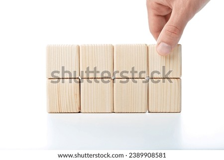Hand putting and stacking blank wooden cubes on table with copy space for input wording or infographic icon.