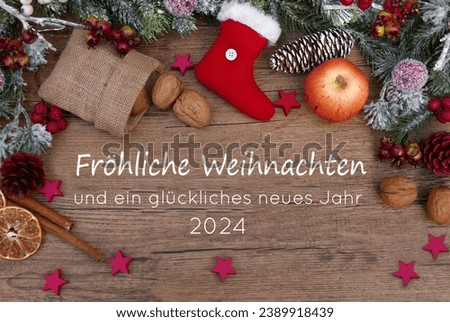 Christmas and New Year greetings on a rustic wooden board with Christmas decorations. German text translated means Merry Christmas and a Happy New Year 2024.