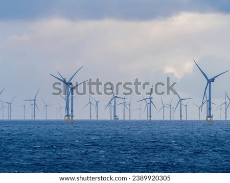 Offshore and Onshore Windmill farm Westermeerwind, Windmill park in the Netherlands with huge large wind turbines, group of windmills for renewable electric energy Royalty-Free Stock Photo #2389920305