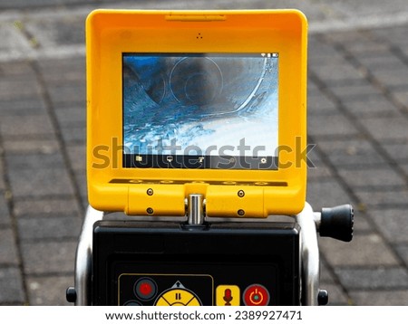 A drain cleaning company checks a blocked drain with a camera before flushing it out. Screen shows the cleaning process of the blocked pipe. Royalty-Free Stock Photo #2389927471