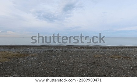 Black sea beach in Kobuleti Georgia with stones and ocean with view of Batumi with rocks and pebbles