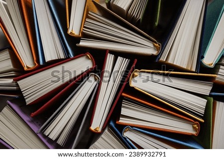 Books opened on the side on the table top view. Colorful book covers and pages texture. Education and business background. Reading hobby,  back to school textbook preparations. Book archive details Royalty-Free Stock Photo #2389932791