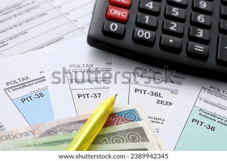 Declaration of the amount of earned income or incurred loss, PIT-36, PIT-36L, PIT-37 and PIT-38 tax forms on accountant table with pen and calculator close up Royalty-Free Stock Photo #2389942345